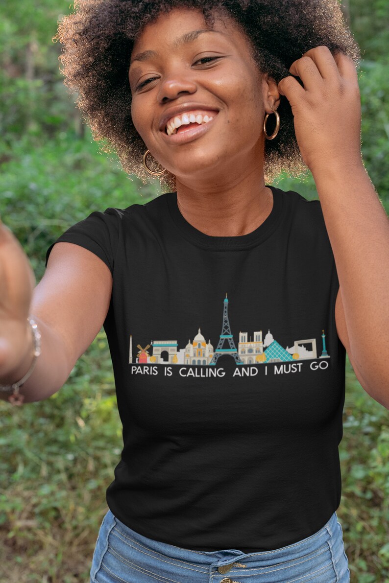 May include: A black t-shirt with a graphic of the Paris skyline and the text "Paris is calling and I must go".