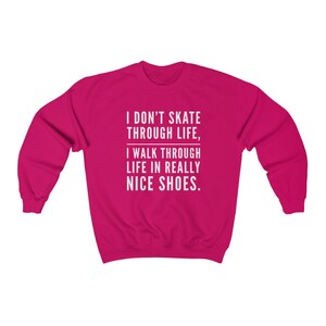 May include: A pink sweatshirt with the text "I don't skate through life, I walk through life in really nice shoes."