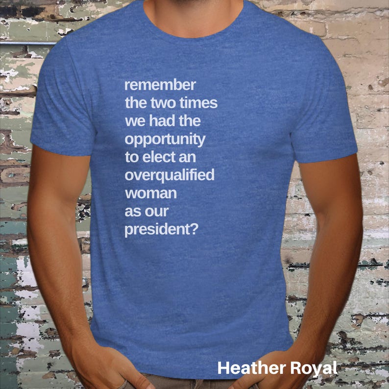 May include: A blue heather t-shirt with white text that reads "remember the two times we had the opportunity to elect an overqualified woman as our president?" The text is centered on the shirt. The bottom of the shirt has the text "Heather Royal" in white.