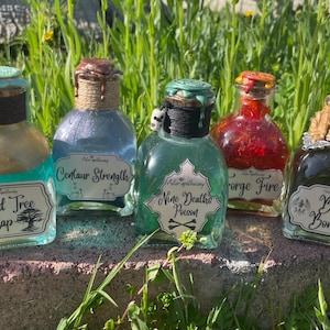 May include: Five small glass bottles with cork stoppers and labels. The bottles contain different colored liquids and have labels with names like "Sacred Tree Sap", "Centaur Strength", "Nine Deaths Poison", "Forge Fire", and "Bat Bones".
