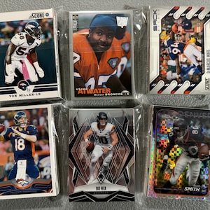 May include: Six collectible football trading cards featuring Denver Broncos players. Cards include Von Miller, Atwater, DiMarcus Ware, Peyton Manning, Bo Nix, and Rod Smith. Each card is in a protective sleeve.