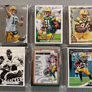 May include: A collection of six Green Bay Packers football trading cards. The cards feature players in their uniforms, with the team's green and gold colors prominent. Some cards have the player's name and team logo.