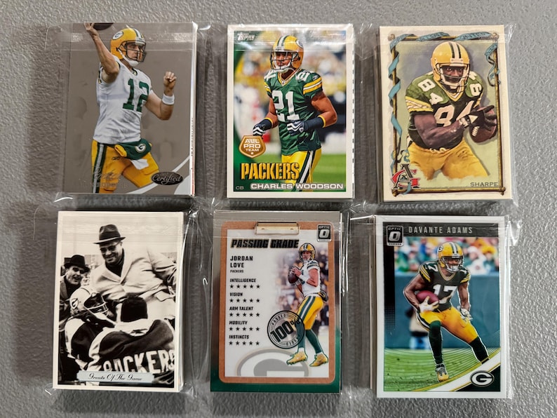 May include: A collection of six Green Bay Packers football trading cards. The cards feature players in their uniforms, with the team's green and gold colors prominent. Some cards have the player's name and team logo.