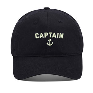 May include: A black cotton baseball cap with an embroidered anchor and the word "CAPTAIN" in white.