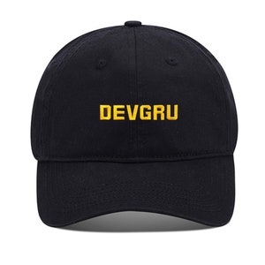 May include: A black baseball cap with a yellow embroidered logo that says "DEVGRU".