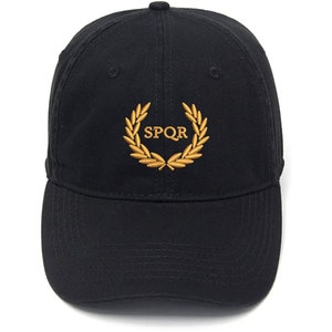 May include: Black baseball cap with a gold embroidered laurel wreath and the text "SPQR" in the centre.