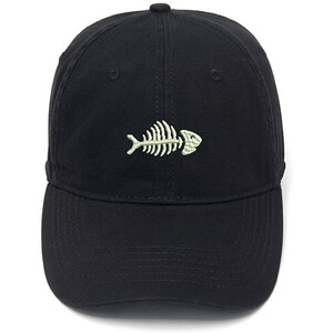 May include: A black baseball cap with a white embroidered fish skeleton design.