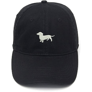 May include: A black baseball cap with a white embroidered dachshund on the front.