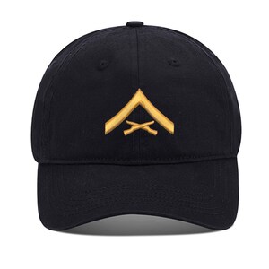 May include: A black baseball cap with a gold embroidered chevron and crossed rifles.