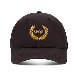 May include: A black baseball cap with a gold embroidered laurel wreath and the text "SPQR" in the center.