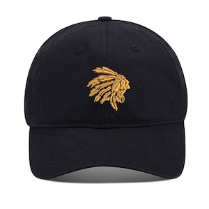 May include: A black baseball cap with an embroidered gold image of a Native American wearing a headdress.