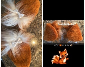 Könnte beinhalten: Fuchs-Ohren-Haarbänder mit braunem und weißem Kunstfell und weißen Schleifen. Das Bild enthält auch eine Grafik eines Fuchses und den Text "FOX PUPPY".