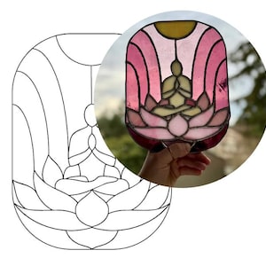 May include: A stained glass window depicting a person meditating in a lotus flower. The window is made of pink, yellow, and clear glass. The person is sitting in a lotus position with their hands in their lap. The lotus flower is in bloom and has many petals.