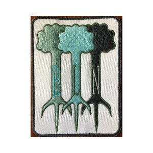 May include: Embroidered patch featuring three stylized trees in shades of green and black, with the letters "BLN" stitched vertically down the trunks. The patch has a white background and a black border.