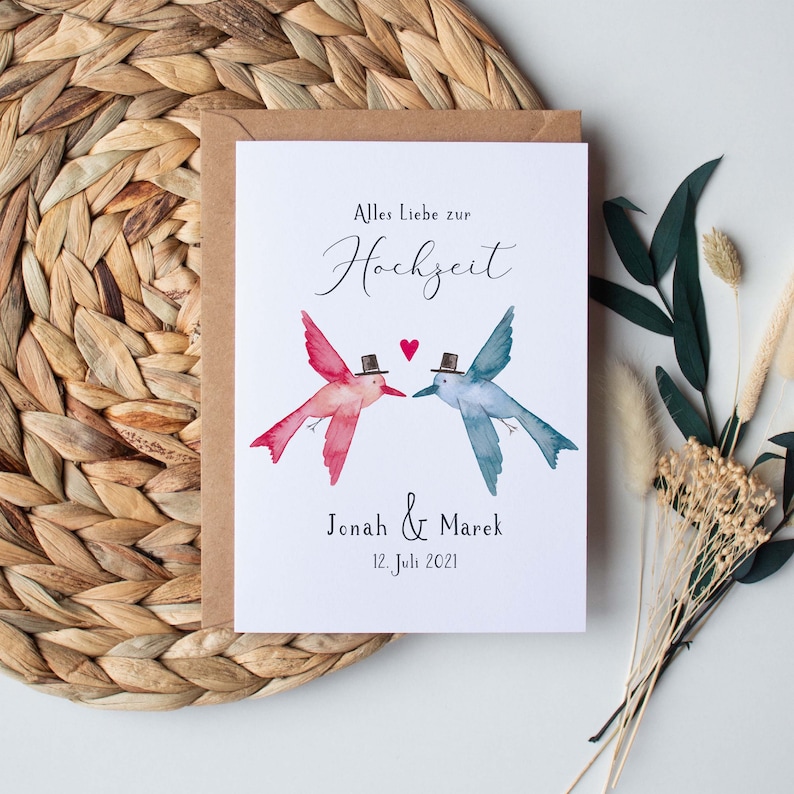 May include: A wedding invitation card with a watercolor illustration of two birds wearing top hats. The text reads "Alles Liebe zur Hochzeit" and "Jonah & Marek 12. Juli 2021".