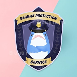 Puede incluir: Un tiburón azul con un sombrero de policía con una insignia dorada que dice "BPS". El tiburón está en un escudo azul y dorado con el texto "BLAHAJ PROTECTION SERVICE".
