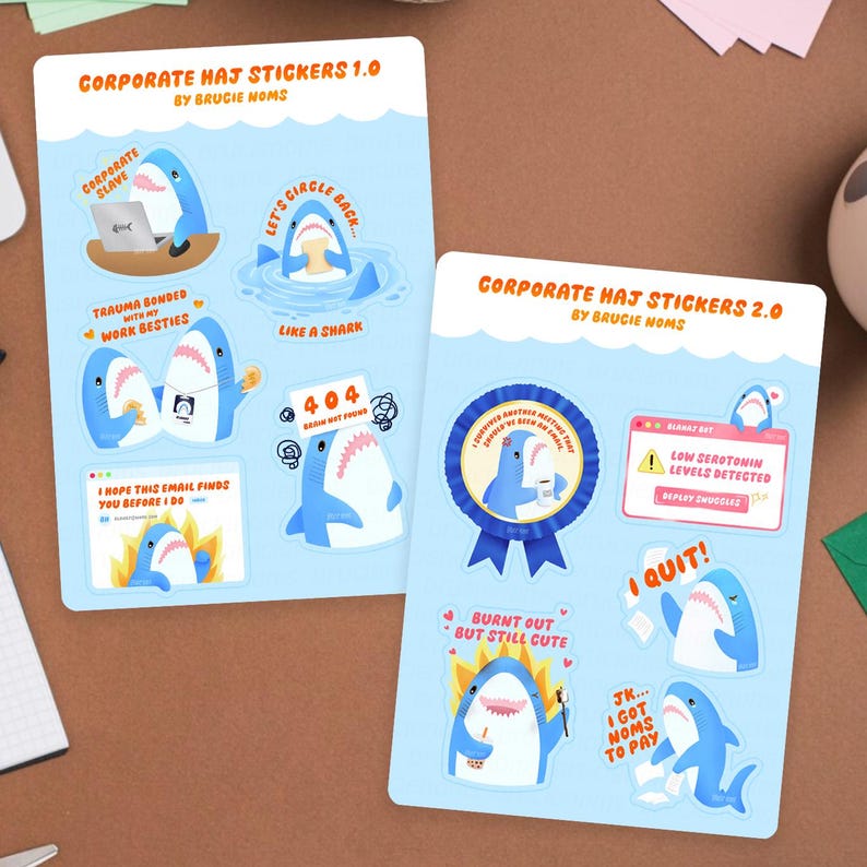 May include: Two sheets of stickers featuring cartoon sharks. One sheet is labelled "Corporate Haj Stickers 1.0" and the other "Corporate Haj Stickers 2.0". The stickers have phrases such as "Let's Circle Back" and "Burnt Out But Still Cute".