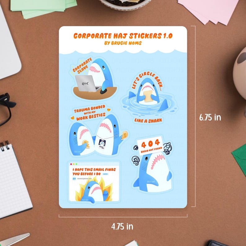 May include: A sticker sheet featuring shark illustrations with text such as "CORPORATE SLAVE" and "TRAUMA BONDED WITH MY WORK BESTIES." The sheet is labeled "CORPORATE HAJ STICKERS 1.0." The sticker sheet measures approximately 12.07 cm x 17.15 cm.