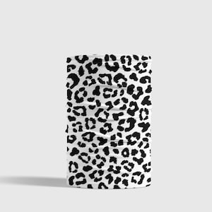 May include: A white and black patterned neck gaiter with a leopard print design.