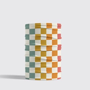 Pode incluir: Uma echarpe tubular de tecido xadrez com fundo branco e quadrados alternados em azul-petróleo, amarelo mostarda e laranja. A echarpe está enrolada e em pé.