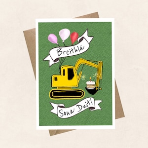 May include: A green card with a yellow digger holding a birthday cake with a lit candle. The digger is surrounded by balloons and a banner that says "Breithla Sona Duit!" which means "Happy Birthday!" in Irish.