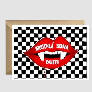 May include: A red vampire mouth with fangs and dripping blood on a black and white chequered background. The mouth says "Breithla sona duit!" which is Irish for "Happy birthday to you!"