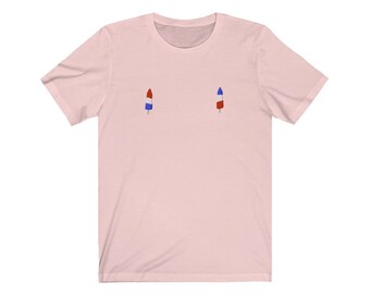 Könnte beinhalten: Ein pinkfarbenes T-Shirt mit einem roten, weißen und blauen Eis am Stiel auf der Vorderseite.