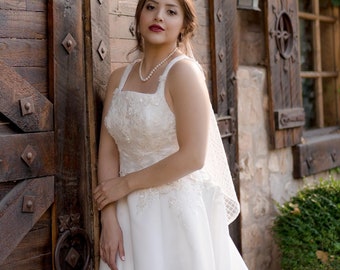 Elegante vestido de novia de los años 50 con encaje floral 3D y corpiño con cuentas: escote cuadrado, cola larga de satén y bolsillos