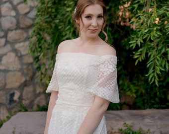 Vestido de novia extravagante con lentejuelas y hombros descubiertos: falda en forma de A, mangas abullonadas, detalles de encaje con cuentas