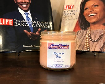 May include: A pink soy wax candle in a clear glass jar with a white label that reads "Astro Scents Mission to Mars" and "A Candle for Lovers 100% Natural Soy Wax".