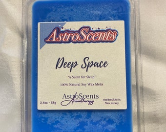 May include: A blue soy wax melt in a clear plastic container. The label reads "Astro Scents Deep Space "A Scent for Sleep" 100% Natural Soy Wax Melts AstroScents Aromatherapy Handcrafted in New Jersey" and "2.4oz. 68g".
