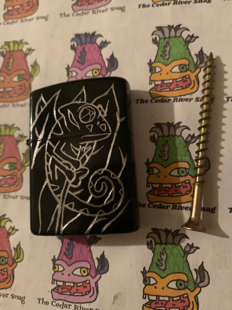 scrawled with a wood screw. A \u201cHobo Engraved\u201d Metal Chameleon Lighter