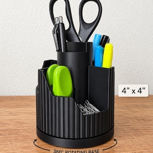 May include: A black desk organizer with a 360-degree rotating base and ribbed exterior texture. The unit features multiple compartments holding scissors, pens, markers, and paper clips. The dimensions are clearly labeled as 4 inches by 4 inches.