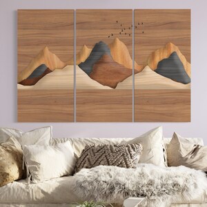 May include: A three-piece wood wall art set featuring a layered mountain landscape with a flock of birds flying overhead. The wood is a light brown color with darker brown and gray accents.