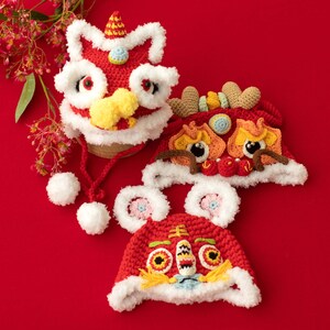 May include: Three red, white and yellow crocheted lion hats with fluffy white trim. The hats have embroidered eyes and a red and yellow lion face.