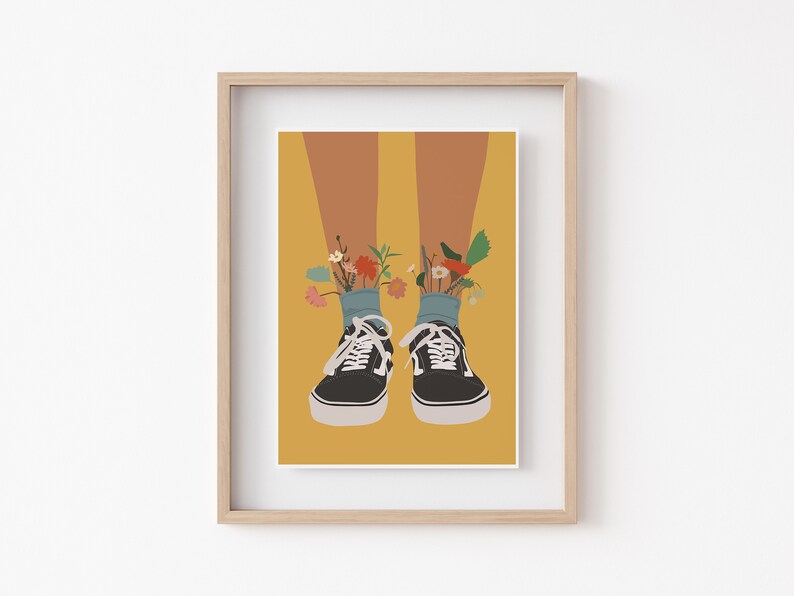 May include: A pair of black canvas trainers with white soles and laces. Flowers are growing out of the tops of the trainers.