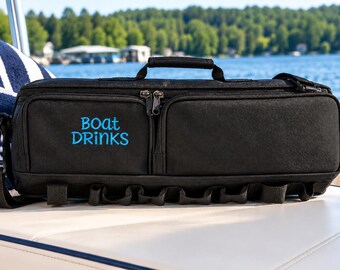May include: A black rectangular insulated cooler bag with a top handle and an adjustable shoulder strap. The front features the text "BOAT DRINKS" embroidered in bright blue thread. The bag includes two zippered front pockets and loops.