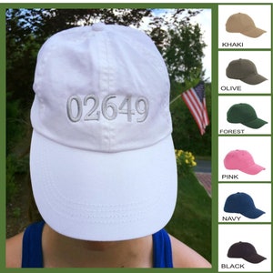 May include: White baseball cap with the embroidered number "02649" in gray. The cap has a curved brim and a fabric strap. Additional color options include khaki, olive, forest green, pink, navy, and black.