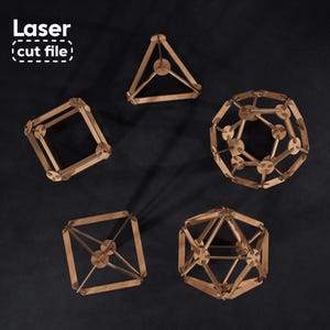 May include: Five geometric structures made of light brown wood, including a tetrahedron, cube, octahedron, dodecahedron, and icosahedron, arranged on a dark surface. The text Laser cut file is visible in the upper left corner of the image.