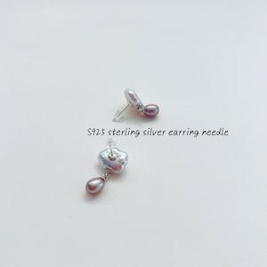 May include: A pair of silver earrings with a single, irregular-shaped pearl and a smaller, round pearl dangling from each earring. The text "S925 sterling silver earring needle" is visible below the earrings.