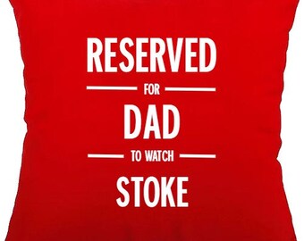 Puede incluir: Cojín rojo con texto blanco que dice "RESERVED FOR DAD TO WATCH STOKE".