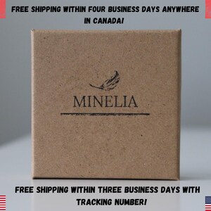 May include: A brown cardboard box with the text "MINELIA" printed on it. The box has a feather design and the text "FREE SHIPPING WITHIN FOUR BUSINESS DAYS ANYWHERE IN CANADA!" printed on the top. The bottom of the box has the text "FREE SHIPPING WITHIN THREE BUSINESS DAYS WITH TRACKING NUMBER!" printed on it.