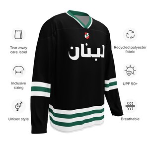 May include: Black and green hockey jersey with the word "لبنان" in white lettering. The jersey has white and green stripes on the sleeves and bottom.