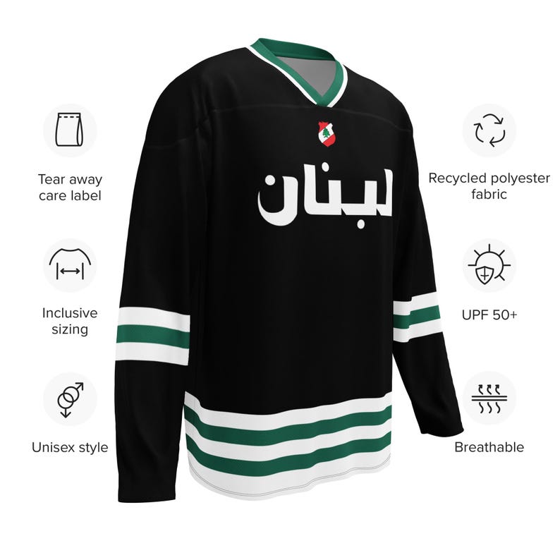 May include: Black and green hockey jersey with the word "لبنان" in white lettering. The jersey has white and green stripes on the sleeves and bottom.