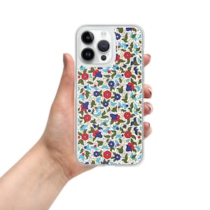 May include: A clear phone case with a floral pattern. The pattern features red, blue, and green flowers on a white background.