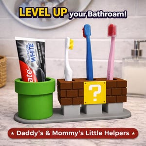 May include: A novelty bathroom organizer featuring a green pipe for toothpaste and a brick-style holder for toothbrushes. The holder has a yellow question mark block. The text "LEVEL UP your Bathroom!" is visible.