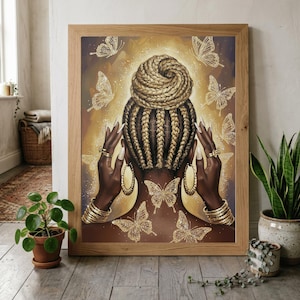 May include: A framed wall art print depicting the back of a person with braided hair styled in a high bun. The figure is adorned with gold hoop earrings, stacked gold bracelets, and rings, surrounded by glowing gold butterflies on a dark background.