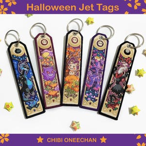 May include: Five Halloween jet tags with embroidered designs and silver key rings. Each tag features a unique character or scene, including a dragon, a purple ghost, and a witch. The text "Halloween Jet Tags" and "CHIBI ONEECHAN" are visible.