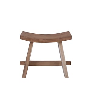 Op de afbeelding: Een houten kruk met een gebogen zitting en een eenvoudig, minimalistisch ontwerp. De kruk is gemaakt van natuurlijk hout met een lichtbruine afwerking.