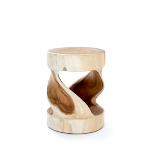 Peut inclure: Une table d'appoint en bois naturel avec un design en forme de sablier. Le dessus et la base ronds sont de couleur claire, tandis que les côtés sculptés révèlent un grain de bois plus foncé. Cette pièce décorative ajoute une touche de style organique.